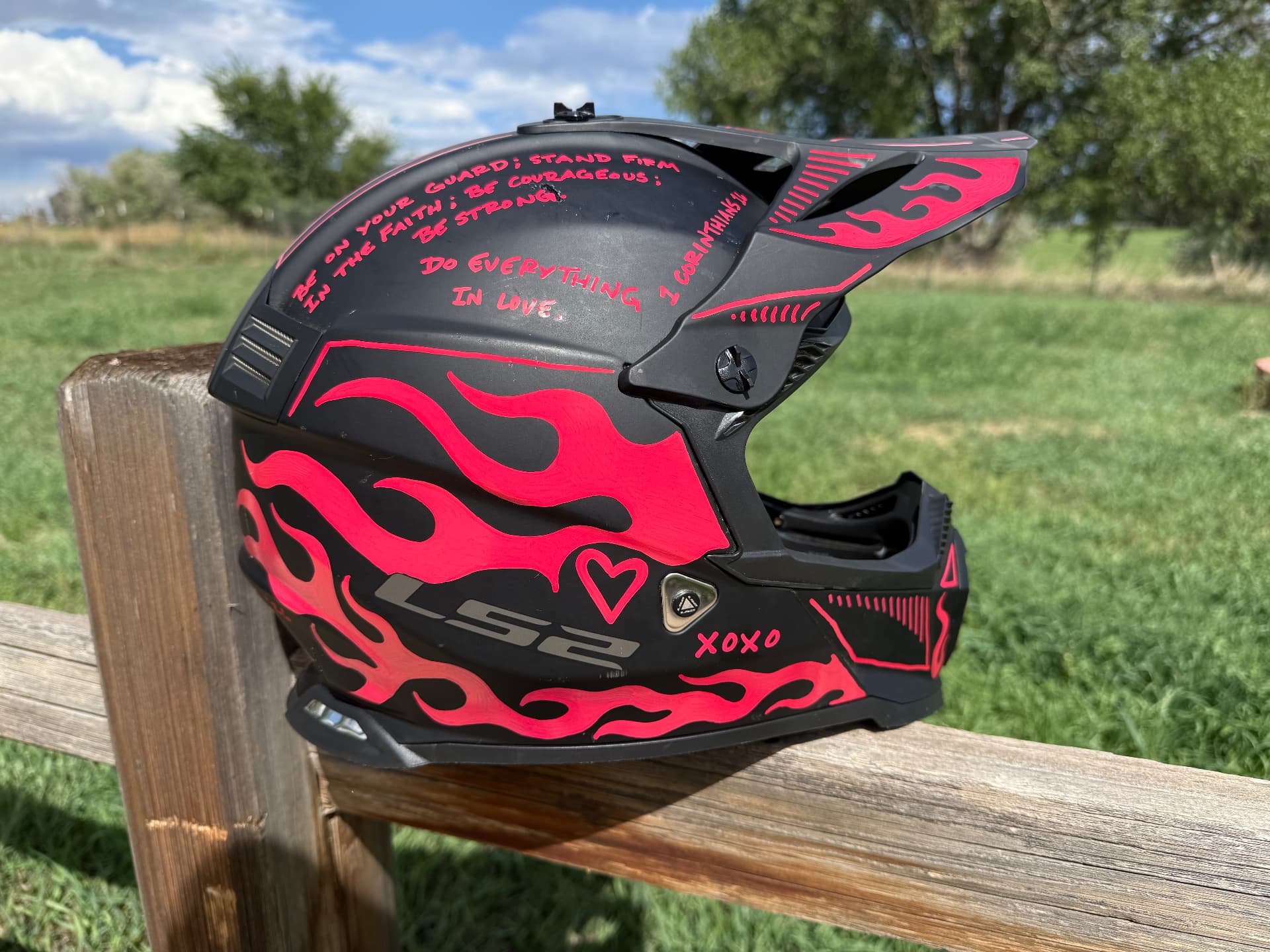Black motocross helmet with hot pink hand-painted flames